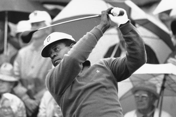 Lee Elder watches the flight of his ball as he tees off in the first round of play at the Masters in Augusta, Ga., on April 10, 1975. Elder broke racial barriers as the first Black golfer to play in the Masters and paved the way for Tiger Woods and others to follow.