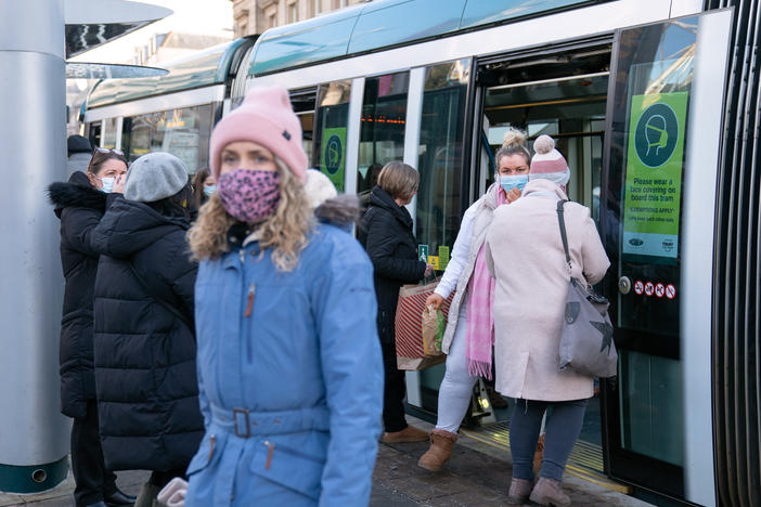 People step off a tram in Nottingham, England, a city where a case of the omicron variant of the coronavirus was identified last week.