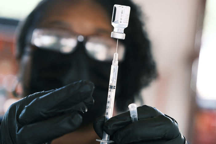 A person prepares to administer a Pfizer COVID vaccine at a clinic in Ferguson, Missouri in August 2021. Merriam-Webster has chosen "vaccine" as the word of the year, citing a sustained surge in lookups.