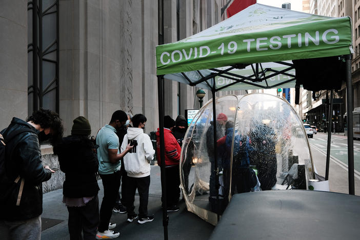 People line up to get tested for COVID at a site in New York City on Monday. The new omicron variant, first detected in South Africa, is quickly spreading around the world.