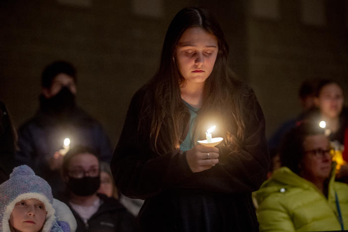 Students hold candles during a prayer vigil after the shootings at Oxford High School on Tuesday in Oxford, Mich.