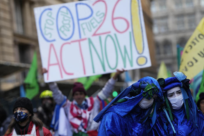 Activists protesting "greenwashing," in which a company or government appears to do more for the environment than it is, gather outside the JP Morgan premises near the COP26 U.N. Climate Summit.