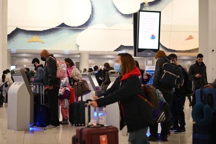 Travelers wear masks at LaGuardia Airport in New York City on Tuesday as concern grows worldwide over omicron, the newest coronavirus variant. Minnesota confirmed the second U.S. omicron case on Thursday, and Colorado the third.