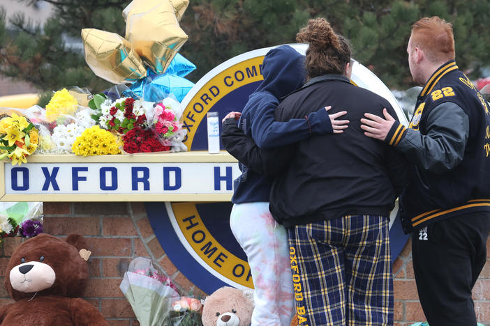 People embrace as they visit a makeshift memorial outside of Oxford High School on Wednesday in Oxford, Mich.