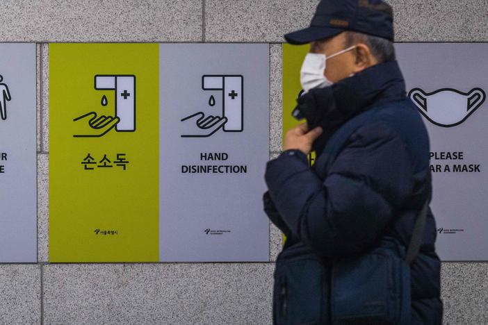 A commuter walks past information boards displayed to remind the public about how to help prevent the spread of the coronavirus in Seoul on Wednesday.