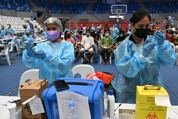 Health workers prepare COVID-19 vaccines at a coliseum in suburban Manila on November 29 — part of a massive 3-day vaccination drive launched by the government. It was one of 8,000 vaccination centers set up during the drive.