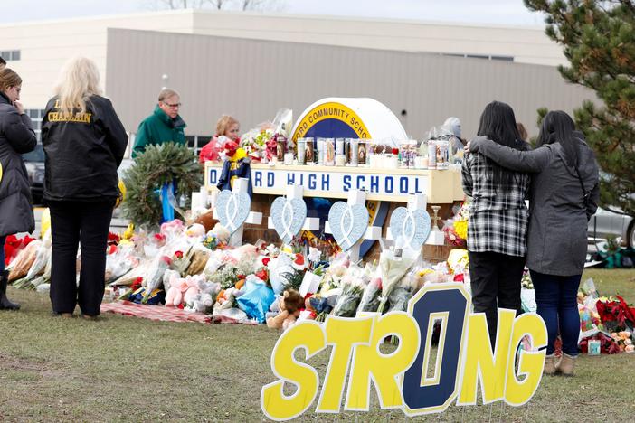 People gather at the memorial for the dead and wounded outside of Oxford High School in Oxford, Mich., on Friday. A 15-year-old has been charged as an adult with murder and terrorism.