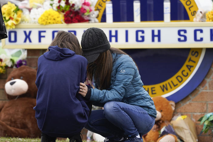 Mourners grieve at Oxford High School in Oxford, Mich., on Wednesday, the day after a gunman opened fire at the school, killing four students and wounding seven other people.