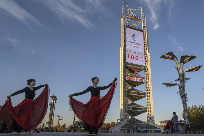 Women practice a dance routine on Oct. 27 in front of a large countdown screen showing 100 days before the opening of the Beijing 2022 Winter Olympics.