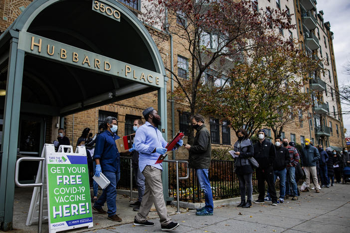 People line up outside a free COVID-19 vaccination site that opened Friday in Washington, D.C. The local health department is stepping up vaccination and booster shots as more cases of the omicron variant are being identified in the United States.