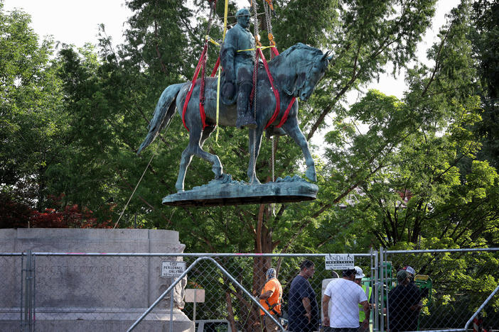 Workers remove a statue of Confederate Gen. Robert E. Lee in Charlottesville, Va., in July. Initial plans to remove the statue four years ago sparked the infamous Unite the Right rally where 32-year-old Heather Heyer was killed.