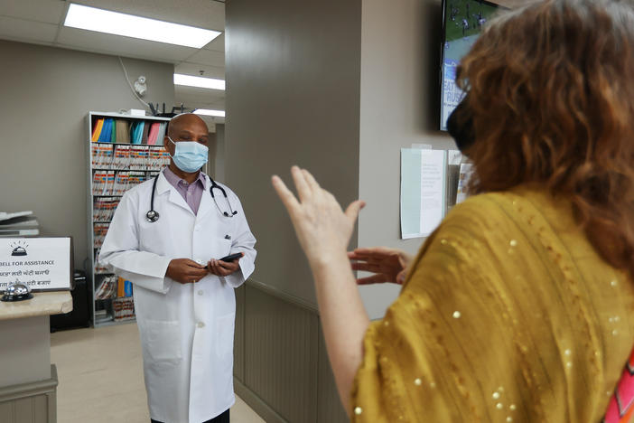 Dr. Naresh Aggarwal talks with Jennifer Bain, who volunteered for a study of Medicago's COVID-19 vaccine, in Toronto. More than 24,000 volunteers in six countries participated.