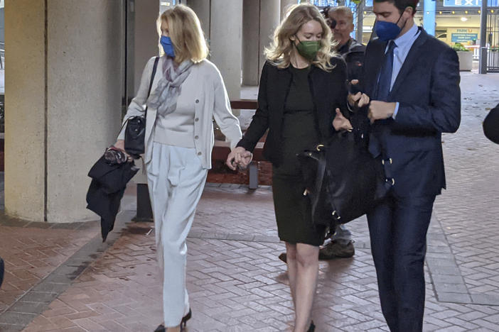 Elizabeth Holmes (center) enters the Robert F. Peckham Federal Building in San Jose, Calif., with her partner, Billy Evans.