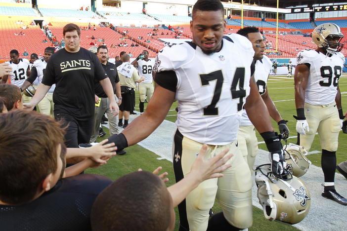 New Orleans Saints defensive end Glenn Foster Jr. greets fans before an NFL preseason game against Thursday, Aug. 29, 2013 in Miami Gardens, Fla. Foster died on Monday while in police custody.