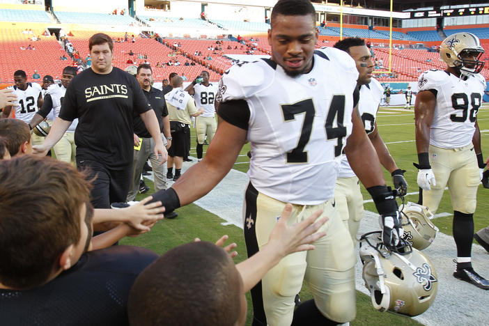 New Orleans Saints defensive end Glenn Foster Jr. greets fans before an NFL preseason game against Thursday, Aug. 29, 2013 in Miami Gardens, Fla. Foster died on Monday while in police custody.