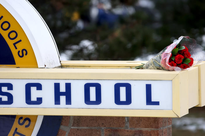 Flowers sit a sign outside Oxford High School a day after a deadly shooting at the school on Dec. 1 in Oxford, Mich.