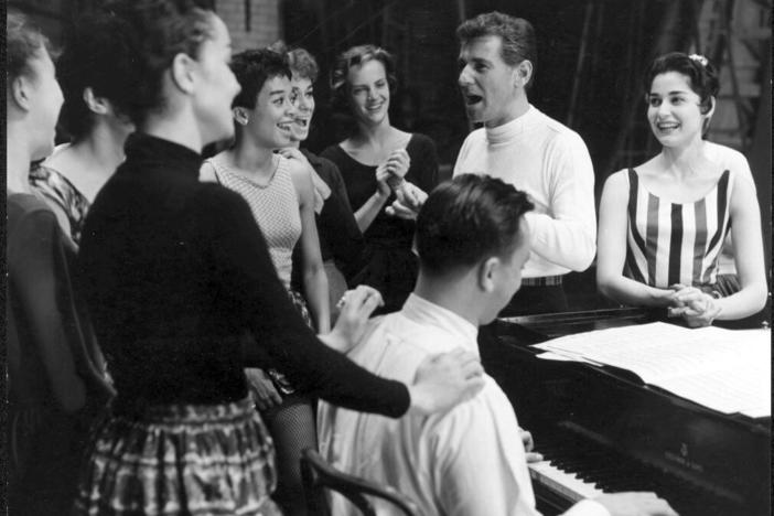 Leonard Bernstein at rehearsal for West Side Story. Carol Lawrence (who played Maria) is at his left, and lyricist Stephen Sondheim is playing the piano, 1957.