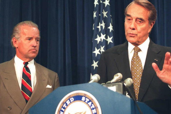 Then U.S. Senate Majority Leader Robert Dole (right) speaks to reporters about the Senate vote to lift the arms embargo over Bosnia on July 26, 1995, as then Sen. Joseph Biden looks on.