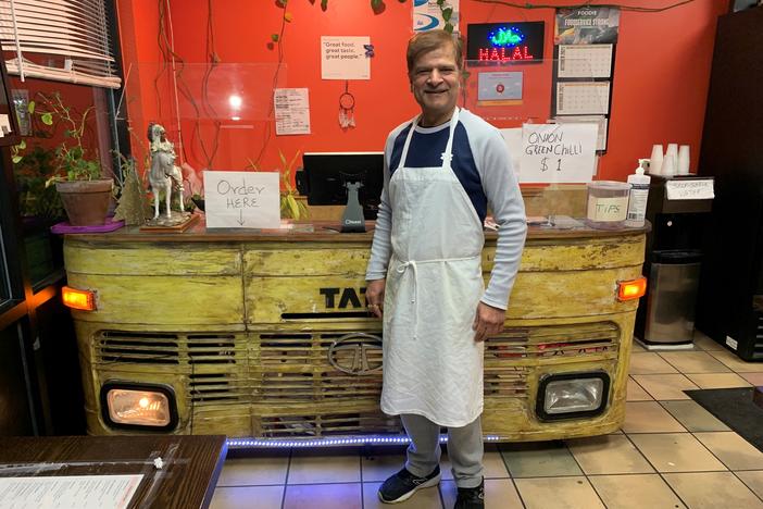 Jagdeep Nayyar, owner and chef at My Taste of India, stands in front of the register stand that's made from the front panel of a real Tata truck — the best-selling brand in India.
