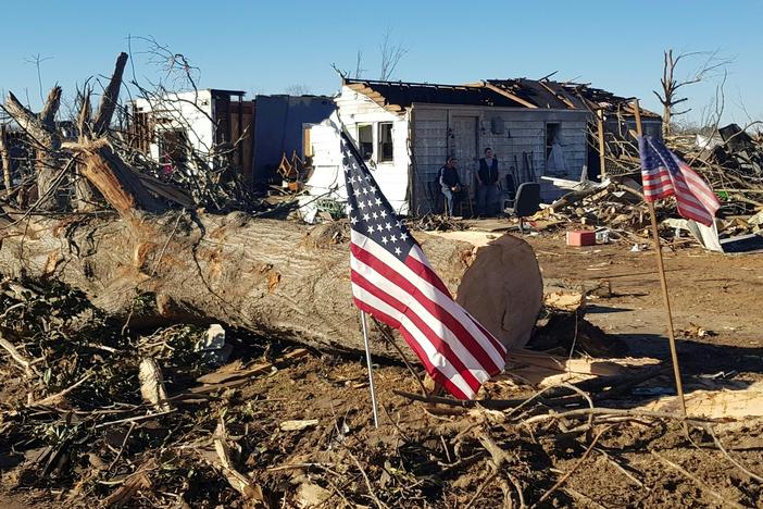 Marty James and a neighbor stand in front of his house in Mayfield, Ky., on Sunday after it was destroyed by a tornado.