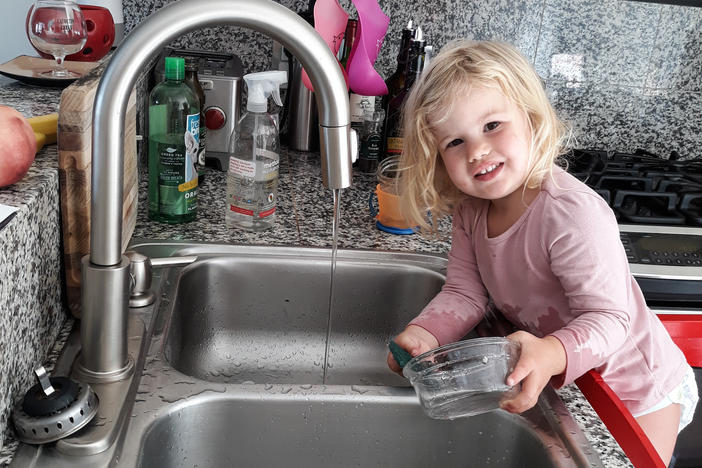 Our correspondent Michaeleen Doucleff's daughter, Rosy, at age 2, as she does dishes voluntarily. Getting her involved in chores did lead to the kitchen being flooded and dishes being broken, Doucleff reports. But Rosy is still eager to help.