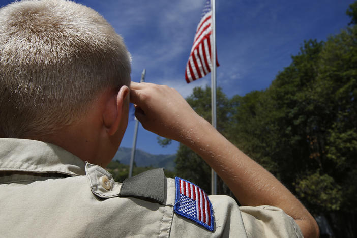 A Boy Scout salutes the American flag at camp Maple Dell in 2015 outside Payson, Utah.