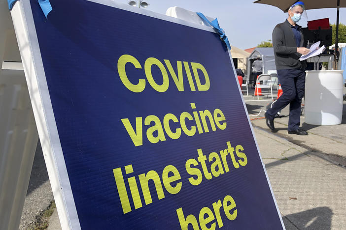 A sign is displayed at a COVID-19 vaccine site in the Bayview neighborhood of San Francisco on Feb. 8, 2021. California is exempting San Francisco from a rule that takes effect requiring all people to wear masks indoors.