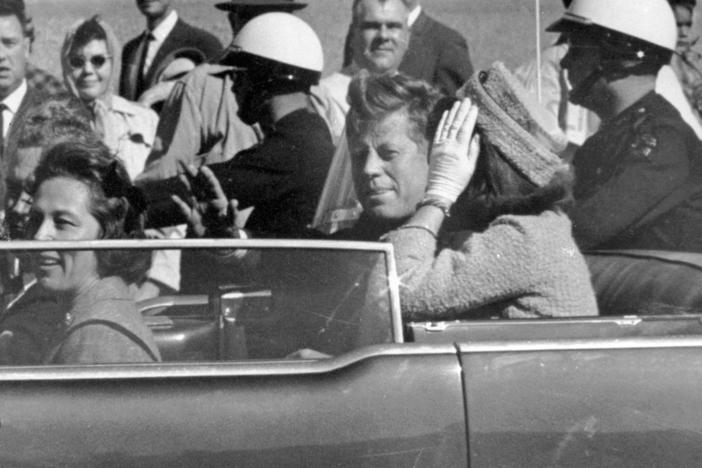 President John F. Kennedy and first lady Jacqueline Kennedy ride in the car in a motorcade in Dallas.