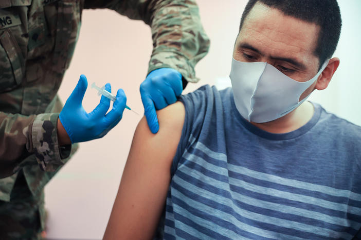 Maryland National Guard Spc. James Truong administers a Moderna COVID-19 vaccine on May 21 in Wheaton, Maryland. People vaccinated with the Moderna vaccine likely need a booster to keep up their protection against the new omicron variant of the coronavirus.