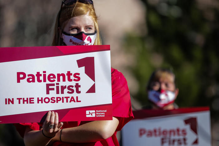 Longmont United Hospital nurse Brooke Schroeder holds a sign supporting nurses December 2, 2021. Nurses say the hospital is severely understaffed and they're trying to form a union.