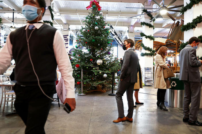 People wear face coverings inside Grand Central Market on Wednesday in Los Angeles. California residents, regardless of COVID-19 vaccination status, are required to wear face masks in all indoor public settings beginning Wednesday.