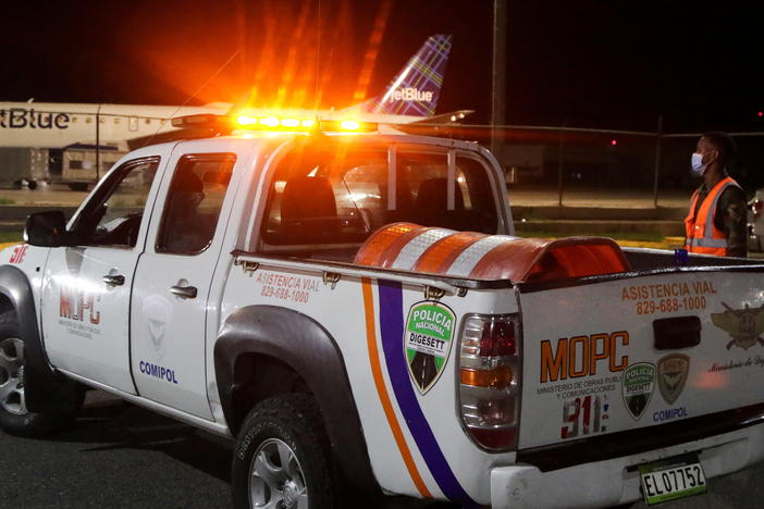 Police stand outside the Las Americas International Airport where a private jet crashed on Wednesday, killing all nine people on board, including Puerto Rican music producer Flow La Movie.