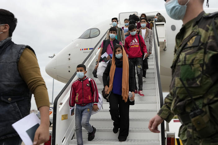 Afghan music students, teachers and their families disembark from their flight to Lisbon on Dec. 13. The group of more than 270 evacuees had been staying in Doha, awaiting resettlement in Portugal.