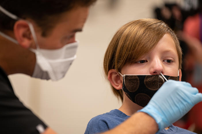 A nurse tests a student for COVID-19 at Brandeis Elementary School in Louisville, Ky.
