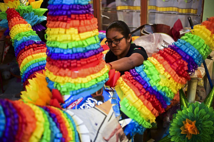 A woman prepares traditional Mexican piñatas for sale at a market in Acolman, Mexico state in 2017.