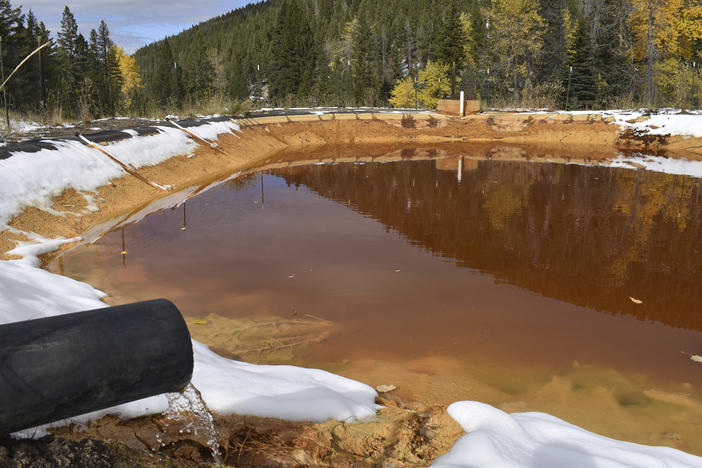 Water contaminated with arsenic, lead and zinc flows from a pipe out of the Lee Mountain mine and into a holding pond near Rimini, Mont., in 2018. It's part of the Upper Tenmile Creek Mining Area Superfund site