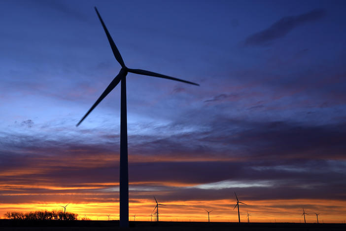 Wind turbines silhouetted against the sky at dawn near Spearville, Kan. in January. Senator Joe Manchin's rejection of a sweeping spending bill effectively kills President Biden's ambitious climate plan to transform the nation's heavily fossil-fuel powered economy into a clean-burning one.