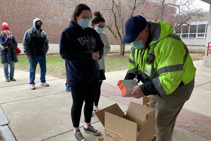 Don Murphy hands out free rapid COVID tests outside of Robinson Middle School in Lowell, Massachusetts.