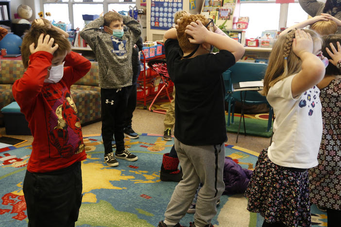 Second-graders hold their heads as they talk about "thoughts" and how they compare with "feelings" and resulting "actions," at Paw Paw Elementary School earlier this month, in Paw Paw, Mich.