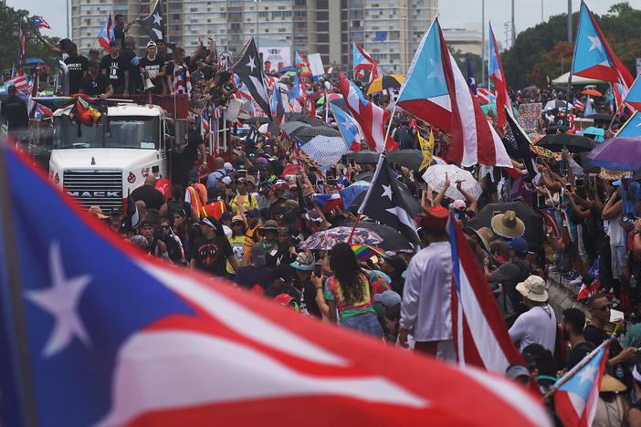 A truck carrying Bad Bunny, Ricky Martin and Residente joins with thousands of other people as they call on Puerto Rican Gov. Rosselló to step down.