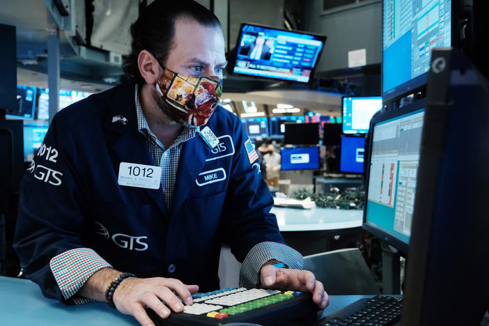 A trader works on the floor of the New York Stock Exchange at the start of trading on Monday. Stocks around the world tumbled over fears of the omicron variant.