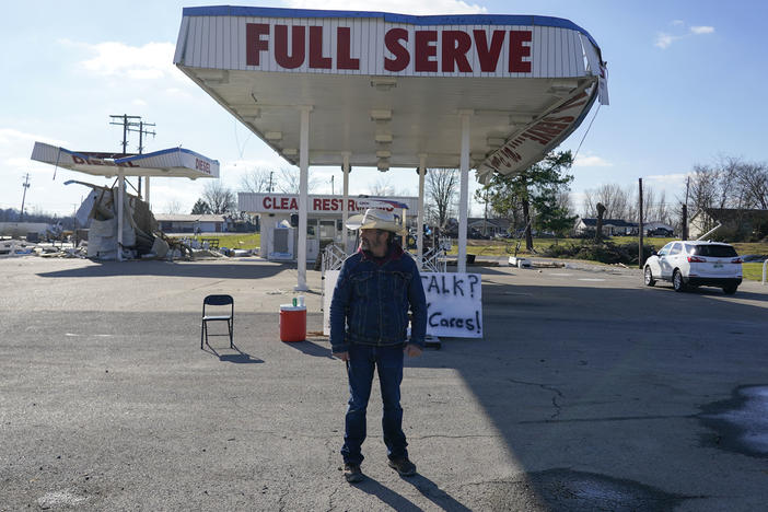Dave 'Cowboy' Graham stands in front of a damaged gas station in Dawson Springs, Kentucky.
