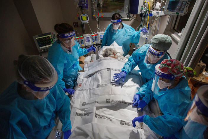 A team of nurses, patient care technicians and a respiratory therapist prepare to return a COVID patient to their back after 24 hours of lying on their stomach. That posture makes it easier to breathe and is a critical part of treatment for COVID patients in hospitals.