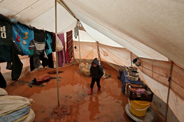 A child walks inside a flooded tent at a camp for the displaced people near Bab al-Hawa by the border with Turkey, in Syria's northwestern Idlib province, on Monday.