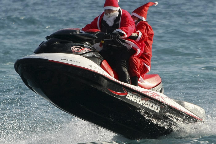 Two men dressed as Santa Claus ride a jet ski on the Mediterranean sea at Villeneuve Loubet, near Nice, southeastern France. (AP Photo/Lionel Cironneau)