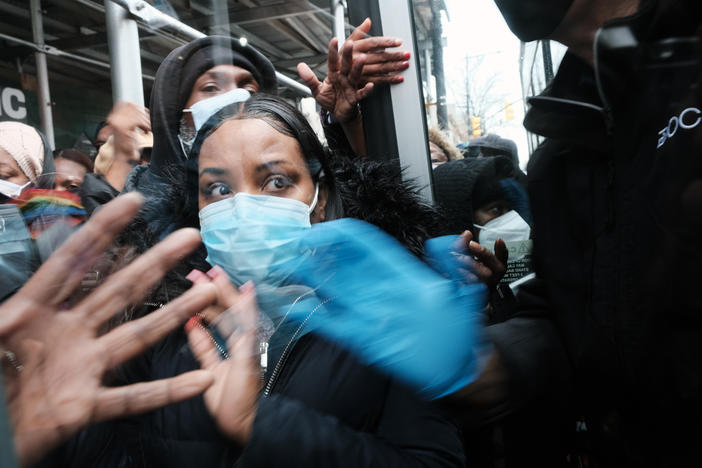 People form a large crowd as they attempt to receive COVID-19 testing kits from city workers distributing the kits along Flatbush Avenue on December 24, 2021 in the Brooklyn borough of New York City. The city is handing out thousands of the kits, which include two tests per box, in order to lesson the surge of people in long lines at testing sites.