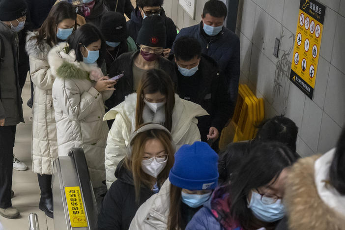 Commuters wearing face masks  ride an escalator at a subway station in the central business district in Beijing. Caseloads of omicron have remained relatively low in many parts in Asia.