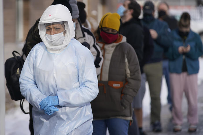 A member of the Salt Lake County Health Department COVID-19 testing staff walks past a line outside the department on Tuesday. The number of new COVID019 cases hit a record this week, topping numbers from January.