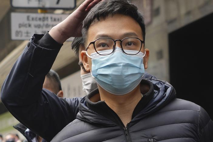 Patrick Lam, an editor at Stand News, is escorted into a van by police officers after they searched for evidence at his office in Hong Kong, Wednesday, Dec. 29, 2021.