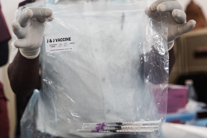 A health care worker holds doses of J&J vaccines at the Gandhi Phoenix Settlement in Bhambayi township, South Africa, on Sept. 24. A study of the J&J booster shot in the country had promising results against the omicron variant.